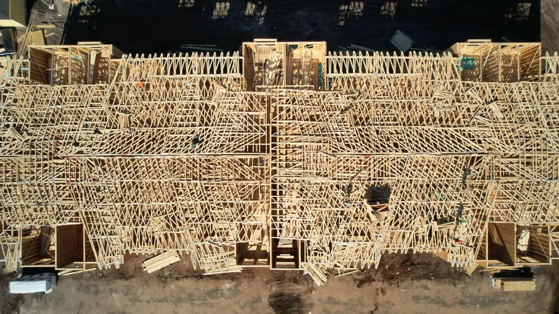Straight-down aerial of a completed Howland roof truss system spanning an entire building, the trusses set at regular spacing and braced off.
